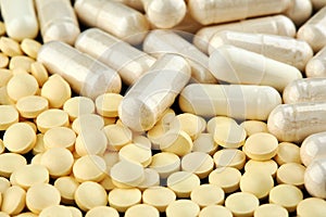 Close-up photo of many white and yellow pills