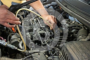 close-up photo of a mechanic's hands repairing a car diesel engine