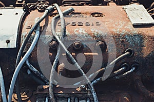 Close-up photo of the mechanical components of an old rusty steam locomotive.