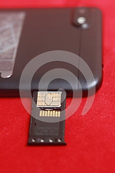 Close Up Photo Micro SD Card Memory in Slot at Smartphone at Red Background