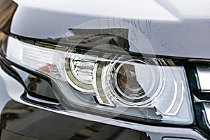 Close up photo of modern car, detail of headlight. Headlight car Projector LED of a modern luxury technology and auto detail