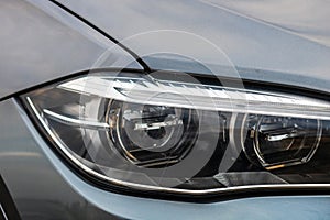 Close up photo of modern and clean car, detail of headlight. Headlight car Projector/LED of a modern luxury technology and auto