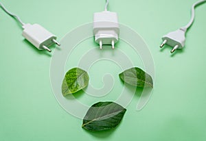 Close up photo of multiple unplugged charging sockets and green leaves.