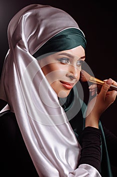 Close-up photo of Muslim female putting on makeup