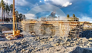 Close up photo of new bridge building site with timbering construction for further filling it with concrete. Yellow crane tower,