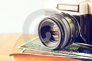 Close up photo of old camera lens over wooden table. image is retro filtered. selective focus