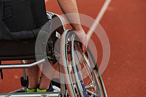 Close up photo of a person with disability in a wheelchair training tirelessly on the track in preparation for the