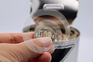 Close-up of a person holding a 500 yen coin