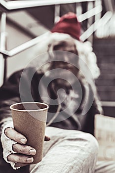 Close up photo of plastic cup which holding by old man.