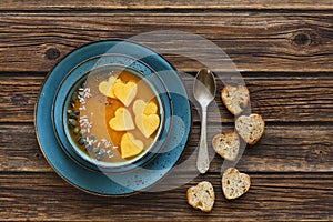 Close-up photo of the plate with fresh homemade pumpkin cream soup with seeds and heart shape toasts