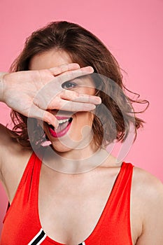 Close-up photo of playful curly brunette woman looking at camera