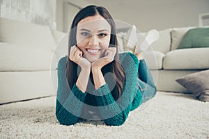 Close-up photo portrait of beautiful pretty calm with toothy beaming smile having rest on soft clean fluffy carpet near