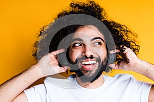 Close-up photo. Portrait of happy african american guy with beard listening to music on headphones