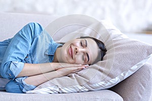 Close up photo portrait of young beautiful woman sleeping on sofa smiling through sleep