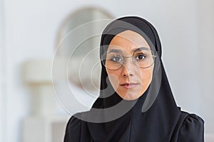 Close-up photo. Portrait of a young woman, an immigrant, a refugee from eastern countries, wearing a black hijab and