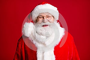 Close up photo of positive cheerful santa claus look in camera wear red costume hat isolated over shine vivid color