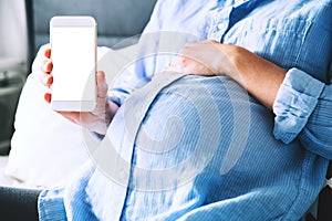 Pregnant woman holding and showing mobile phone with empty display