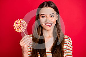 Close-up photo of pretty cute nice glad charming gorgeous lady holding swirl colorful candy on stick isolated bright