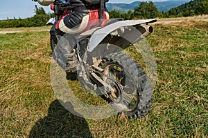 Close up photo of a professional motocross rider in action, showcasing the tire and various components of the motorcycle