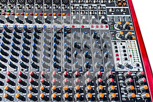 Close up photo of a professional sound mixer with many adjustments, knob switches and buttons of audio mixer control panel.