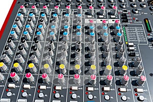 Close up photo of a professional sound mixer with many adjustments, knob switches and buttons of audio mixer control panel.