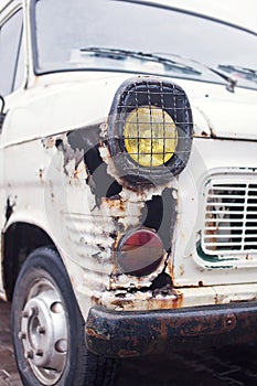 Close-up photo of rusty wing white truck