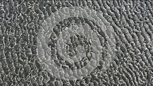 Close-up photo of Sand of beach with a unique and intricate pattern. The pattern on the floor is reminiscent of veins or sinews,