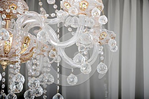 Close-up photo of the scenery on the old chandelier. Glass figures shine and reflect light with their faces