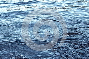 Close up photo of small whirlwinds, swirls in the ocean water. Blue colors and nice lightning. Swirls from boat motor