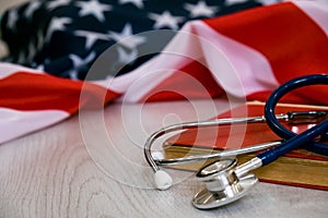 Close-up Photo Of Stethoscope and the red book On American Flag. medicine USA. Education concept. medical degree