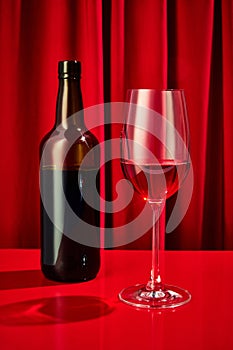 Close up photo of sweet red, pink seasoned wine served in high glass classy and bottle of wine on bar counter at