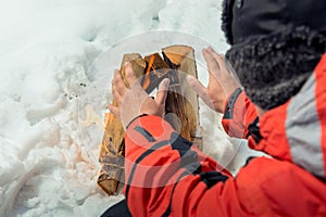 Close-up photo - tourist warms his hands near the fire