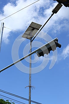 close-up photo of traffic control lights and street lighting based on solar panels isolated on blue sky background