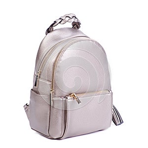 Close-up photo of trendy royal beige leather backpack with two zipped compartments and pocket with an original braided handle