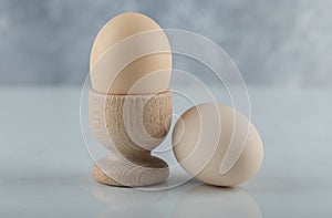 Close up photo Two fresh eggs in eggcup and ground on white background