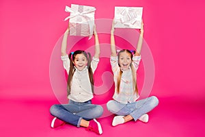 Close up photo two people little age she her girls hold hands arms large gift boxes mom dad anniversary sit floor wear