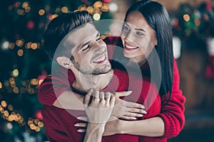 Close up photo of two people romantic dreamy man and woman hug gently piggyback in house with newyear decoration lights