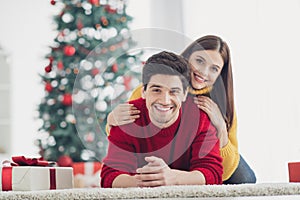 Close up photo of two people spouses wear red yellow comfy jumpers lying on floor enjoy christmas party newyear