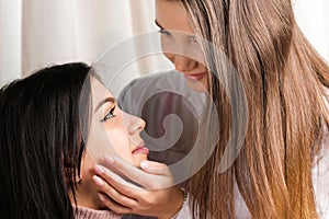 Close up photo of two pretty girls female couple brunette and blond looking at each other with love passing tender