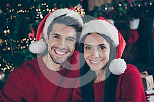 Close up photo of two romantic married people enjoying christmas celebrate x-mas holidays wearing newyear hat in house
