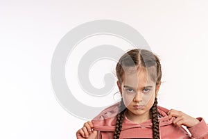 Close up photo of an upset, angry little girl with pigtails isolated over white background