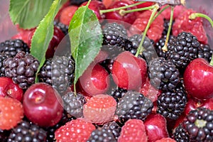 Close up photo of various berries - cherries, blackberries, raspberry