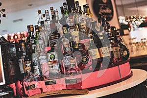 A close-up photo of various types of alcoholic bottles lined up on a bar shelf. Perfect for showcasing bar and nightlife scenes