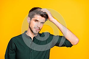 Close up photo of virile confident man touching his hair worried about its falling off isolated over vivid color yellow