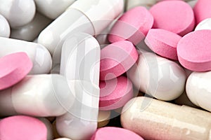 Close-up photo of white capsules and pink pills