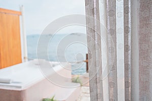 Close-up photo of white curtains and sea view background