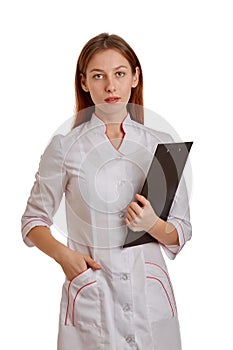 Close-up photo of a woman doctor in a white coat. The doctor monitors the records of the medical history, drugs