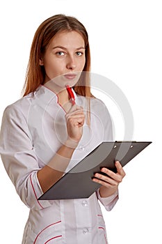 Close-up photo of a woman doctor in a white coat. The doctor monitors the records of the medical history, drugs