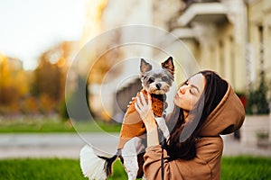 Close-up photo, a woman holding a biewer terrier dog and looking away. Walk with pet concept. Close-up photo, a woman holding a