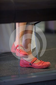 Close up photo of woman legs in rubber shoes.